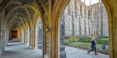 Image of person walking by arches of Abele Chapel Duke University